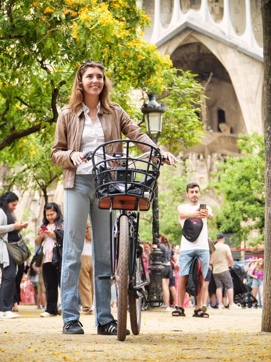 Girl biking in front of Sagrada Familia in Barcelona on a personalised and custom-made bike for hotels