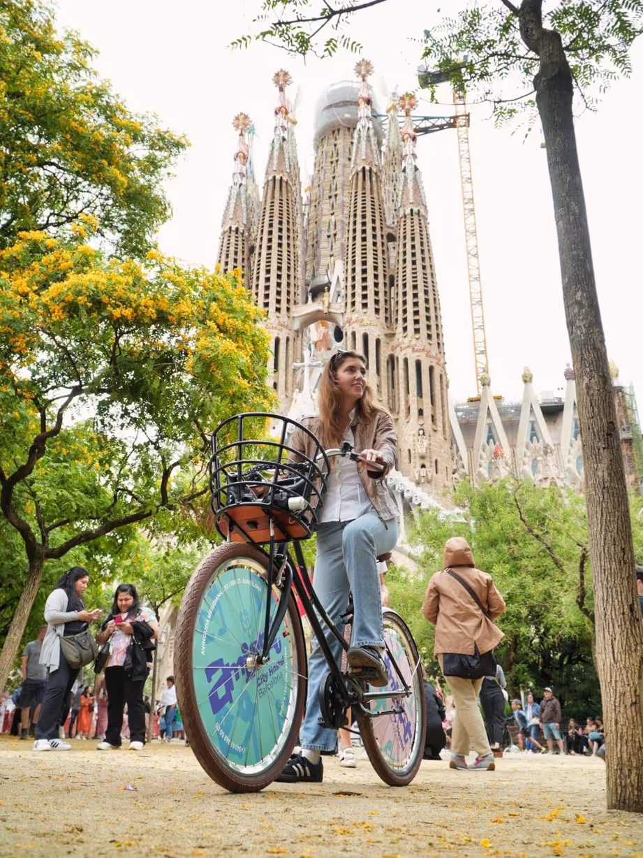Girl biking in front of Sagrada Familia in Barcelona on a personalised and custom-made bike for hotels