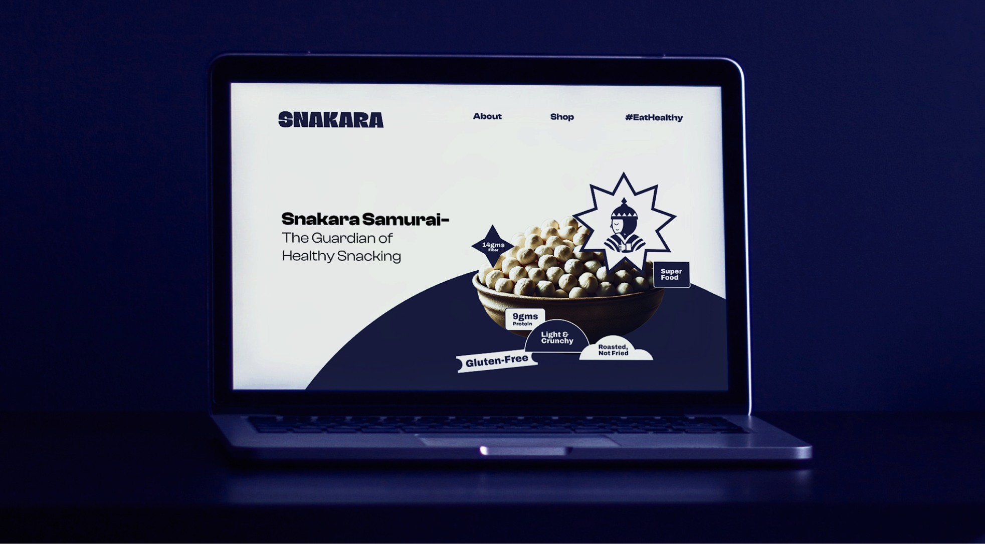 This image shows **Snakara’s website homepage**, introducing the brand’s playful identity and focus on healthy snacking. The hero section highlights the tagline *“Snakara Samurai – The Guardian of Healthy Snacking”*, reinforcing the brand’s mascot as a symbol of strength and mindful indulgence. The central visual features a bowl of roasted makhana (fox nuts) paired with key benefits—*Gluten-Free, Roasted Not Fried, 9g Protein, and 14g Fiber*. The minimal layout and bold typography in deep blue and cream create a modern, energetic aesthetic that feels both fun and premium. Overall, the design captures Snakara’s brand promise: health-forward snacking with an edge of confidence and character.
