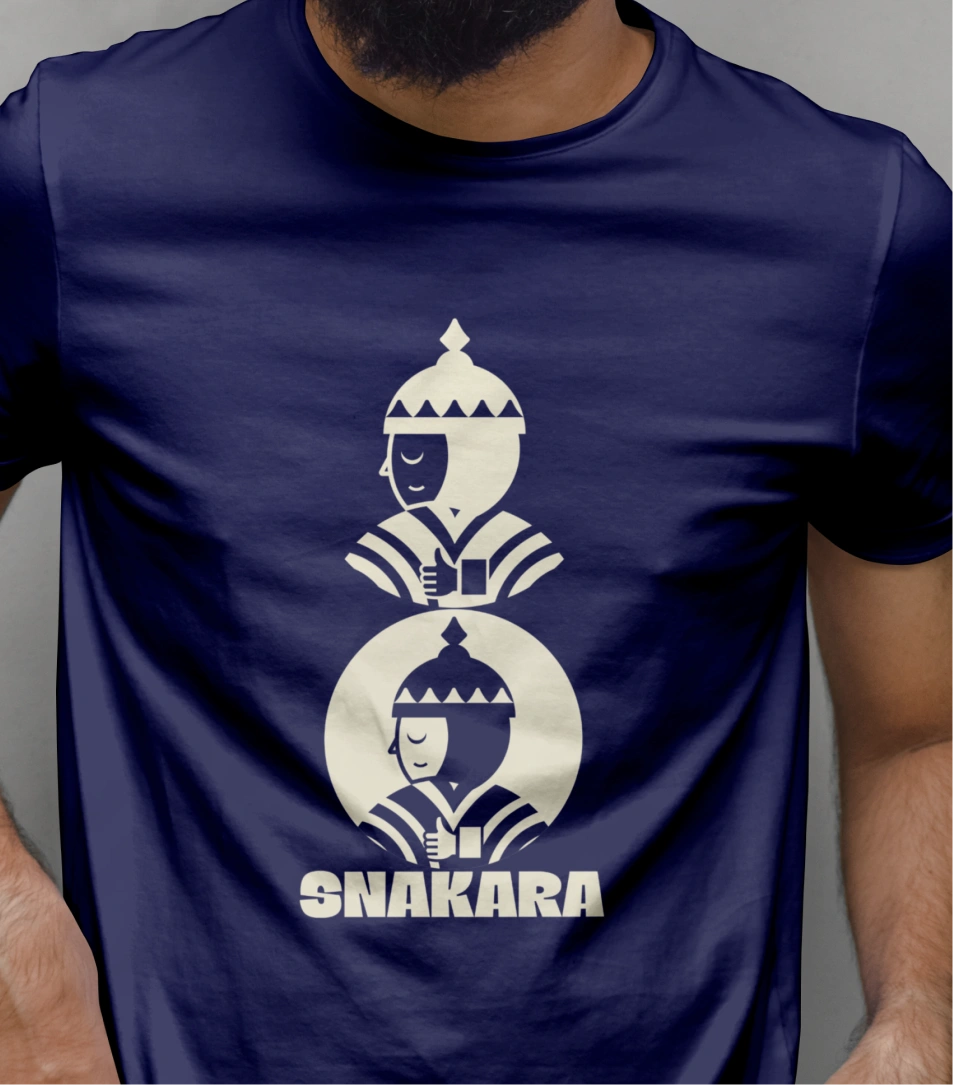 This image showcases Snakara’s brand applied to apparel — a deep navy t-shirt featuring the Samurai mascot in a bold, minimalist print. The stacked composition of two Samurai figures, mirrored and centered, adds symmetry and balance, reinforcing Snakara’s design language of discipline and calm control.

The cream-on-navy contrast mirrors the brand’s signature color palette, while the geometric precision of the illustration reflects the same thoughtful restraint seen across the identity. The large **SNAKARA** wordmark grounds the design, giving it a confident, modern presence. This isn’t just merchandise — it’s wearable branding that turns the Samurai ethos into a lifestyle symbol: mindful, strong, and quietly powerful.

