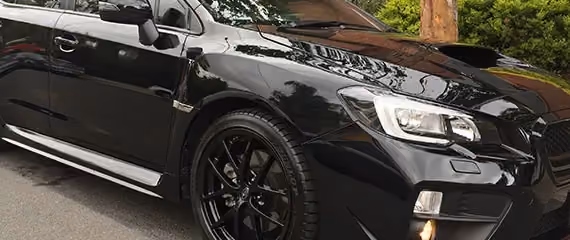 Image of a black Subaru after repair, highlighting its glossy finish and restored condition.