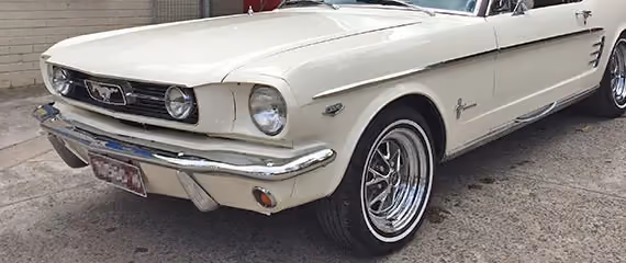 Showcases a Ford Mustang post-repair in a dramatic setting, emphasising the detailed restoration work.