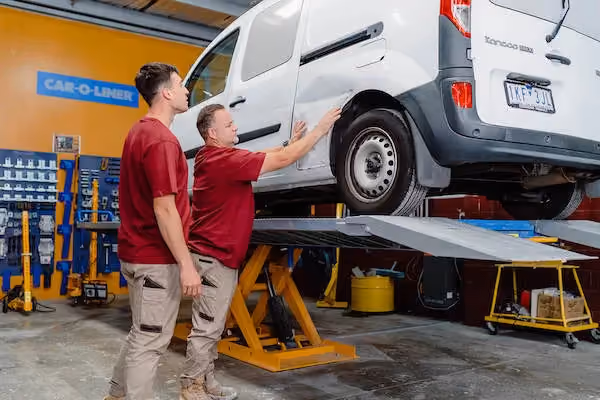 Workshop image capturing the busy and precise environment of vehicle repair at Sheen.