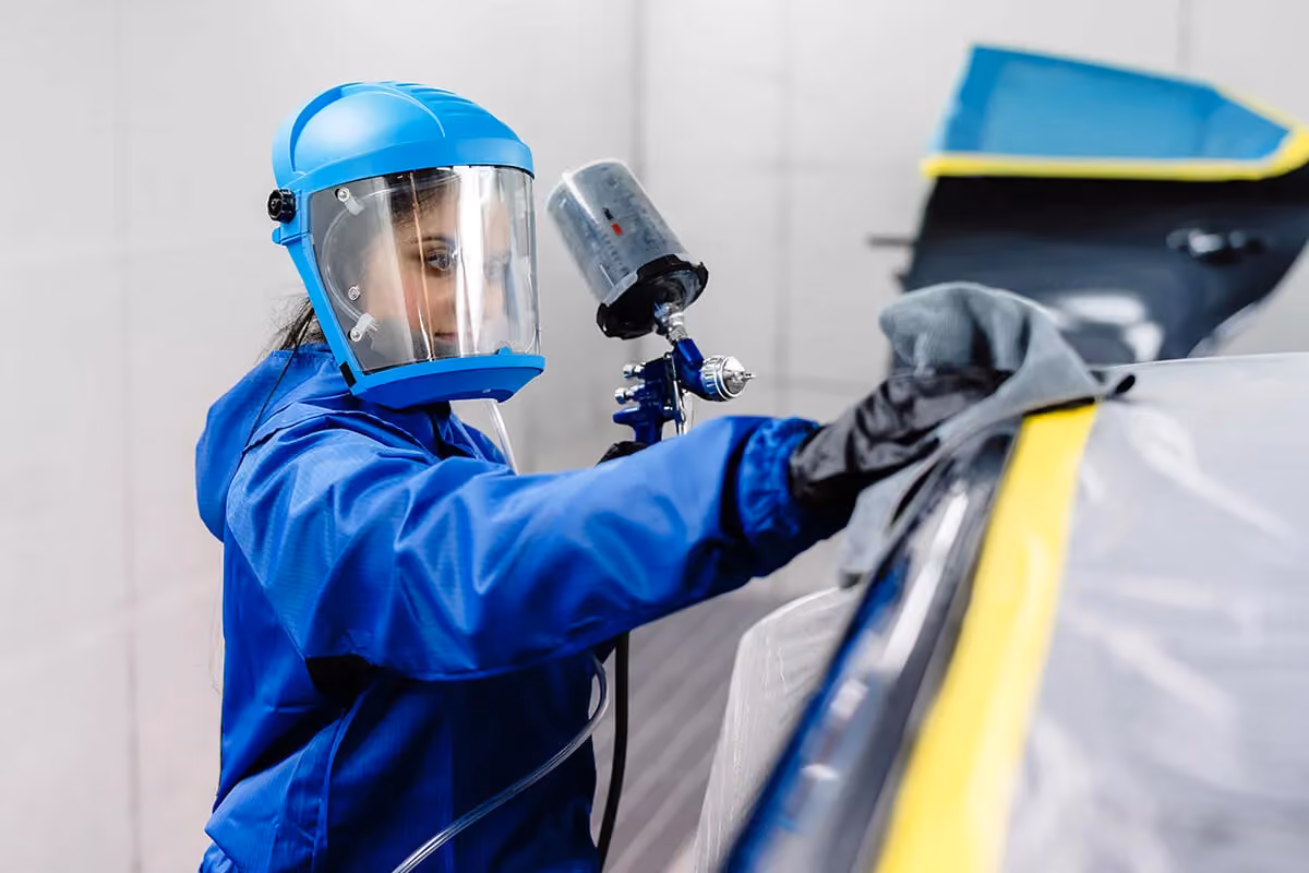 A Sheen smash repair specialist repaints a damaged car.