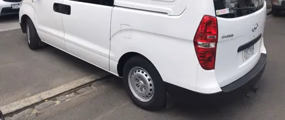 Rear side view of a Hyundai van after repair, showing a restored and clean appearance