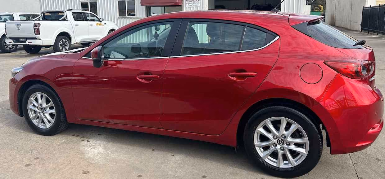 Before repair photo of a Mazda 3, illustrating the initial extensive damage.