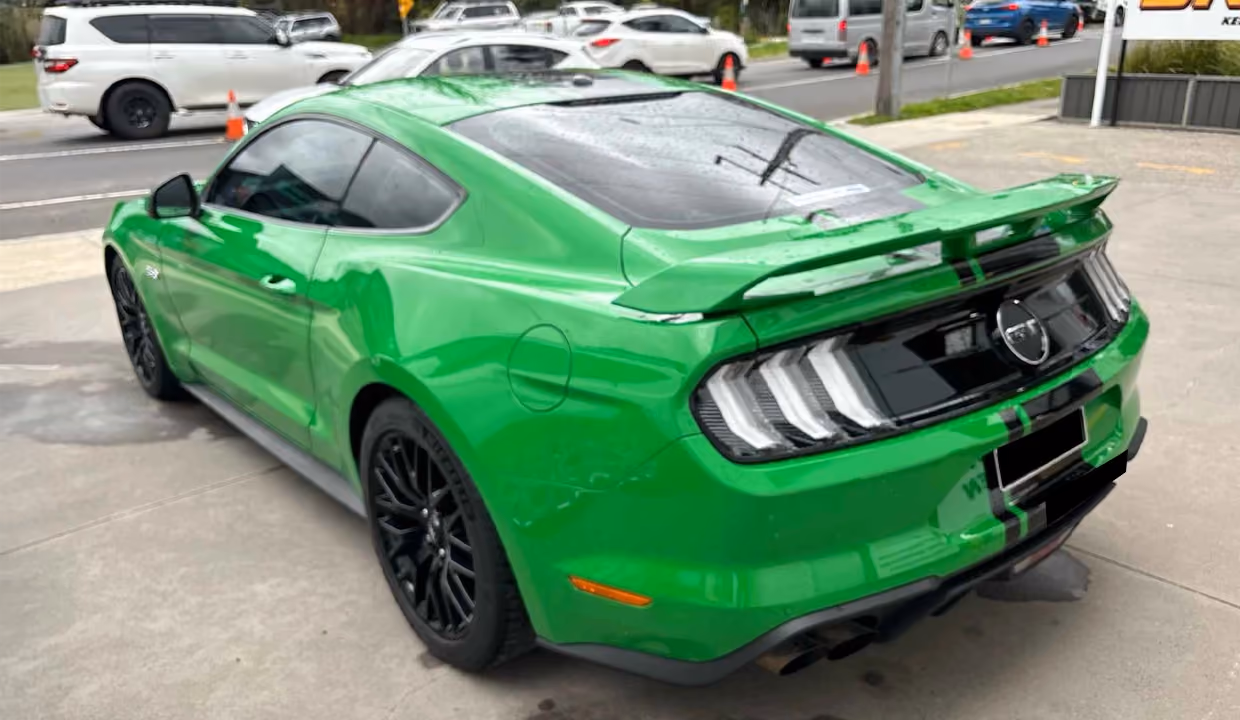 Displays a Ford GT after repair, featuring a flawlessly restored rear quarter and bumper with a sleek, high-gloss finish and no visible signs of damage.