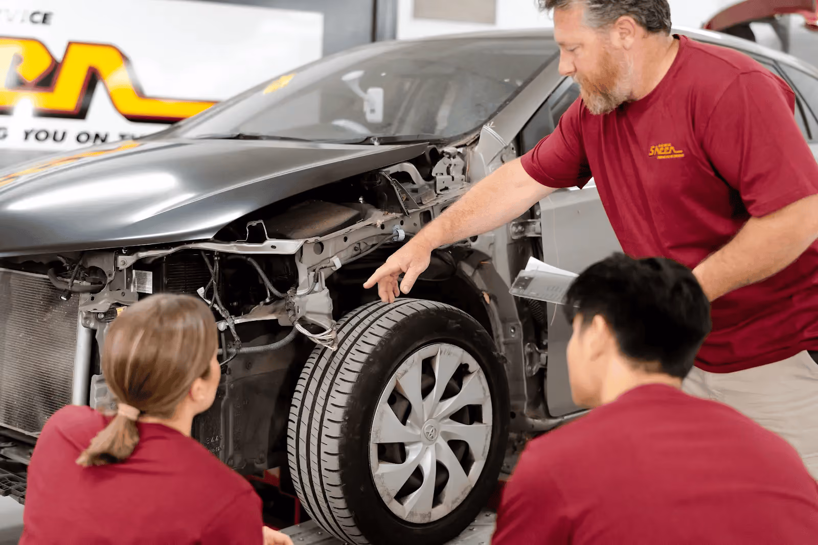 A trio of Sheen’s panel beaters reviewing the damage to the interior components of a vehicle that had struck an animal.