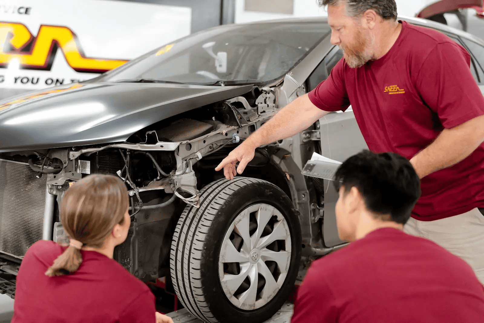 A trio of Sheen’s panel beaters reviewing the damage to the interior components of a vehicle that had struck an animal.