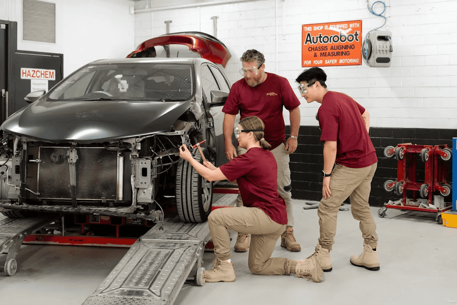 A trio of our mechanics working on a car that’s been severely damaged in an accident.