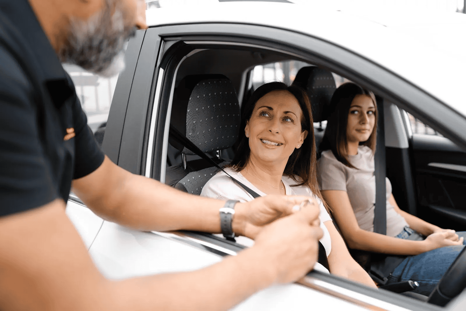 The same specialist as before hands the client the keys to an accident replacement vehicle.