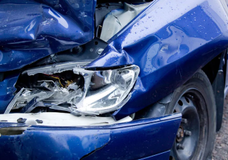 Customer photographing rear bumper damage on a red car with a tablet at the crash site to record details for a car insurance claim and smash repair.