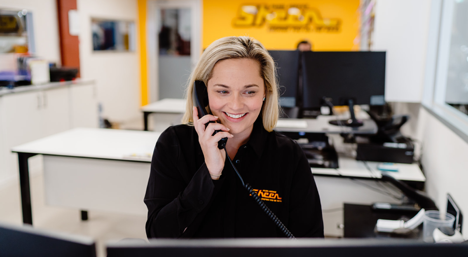 Sheen Panel Service staff member assisting customer with repair enquiry.