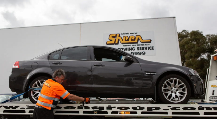 Sheen towing service securing a sedan on flatbed truck in Victoria.
