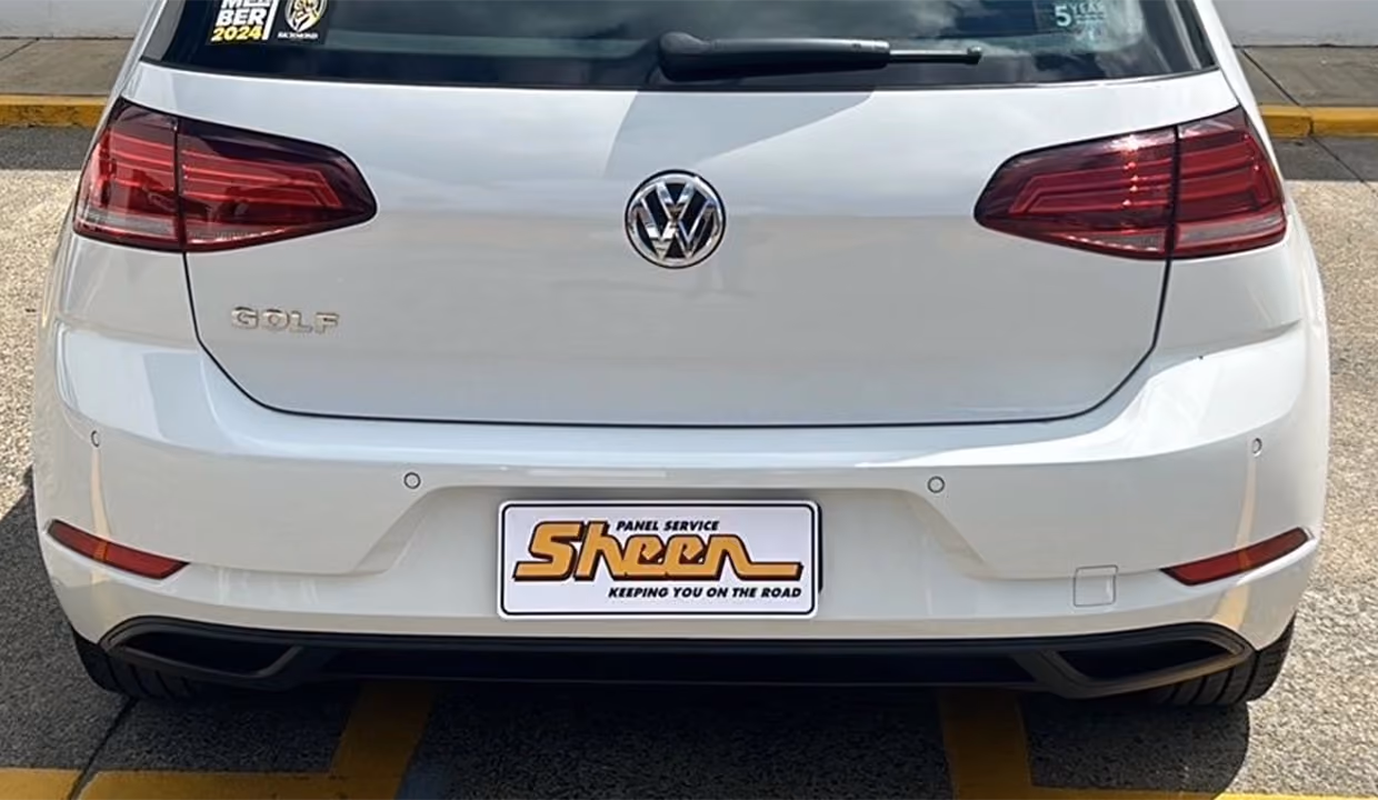 Rear view of a white Volkswagen Golf after repair, with a smooth, clean rear bumper and tailgate restored to like-new condition.