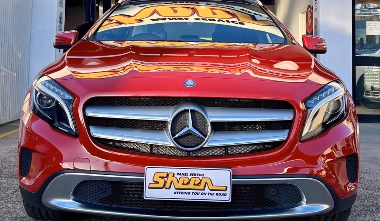 Front view of a red Mercedes-Benz C-Class after repair, with a smooth bonnet, aligned grille, and fully restored front bumper in like-new condition.