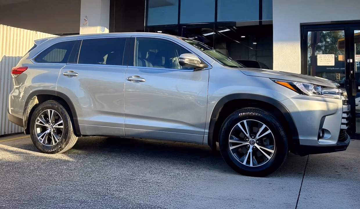 Side view of a silver Toyota Kluger after repair, with smooth, aligned doors and side panels restored to a clean, like-new finish.
