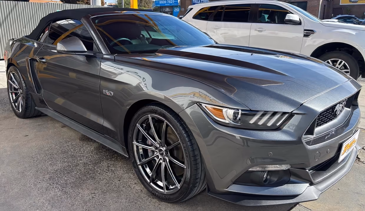 Front-side view of a Ford Mustang Convertible after repair, showing a fully restored bonnet, headlight, and front quarter panel with smooth alignment and a clean, glossy finish.