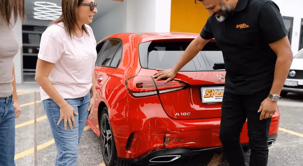 Sheen repair specialist assessing accident damage on a customer's vehicle.