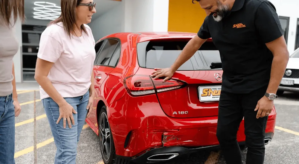 Sheen repair specialist assessing accident damage on a customer's vehicle.