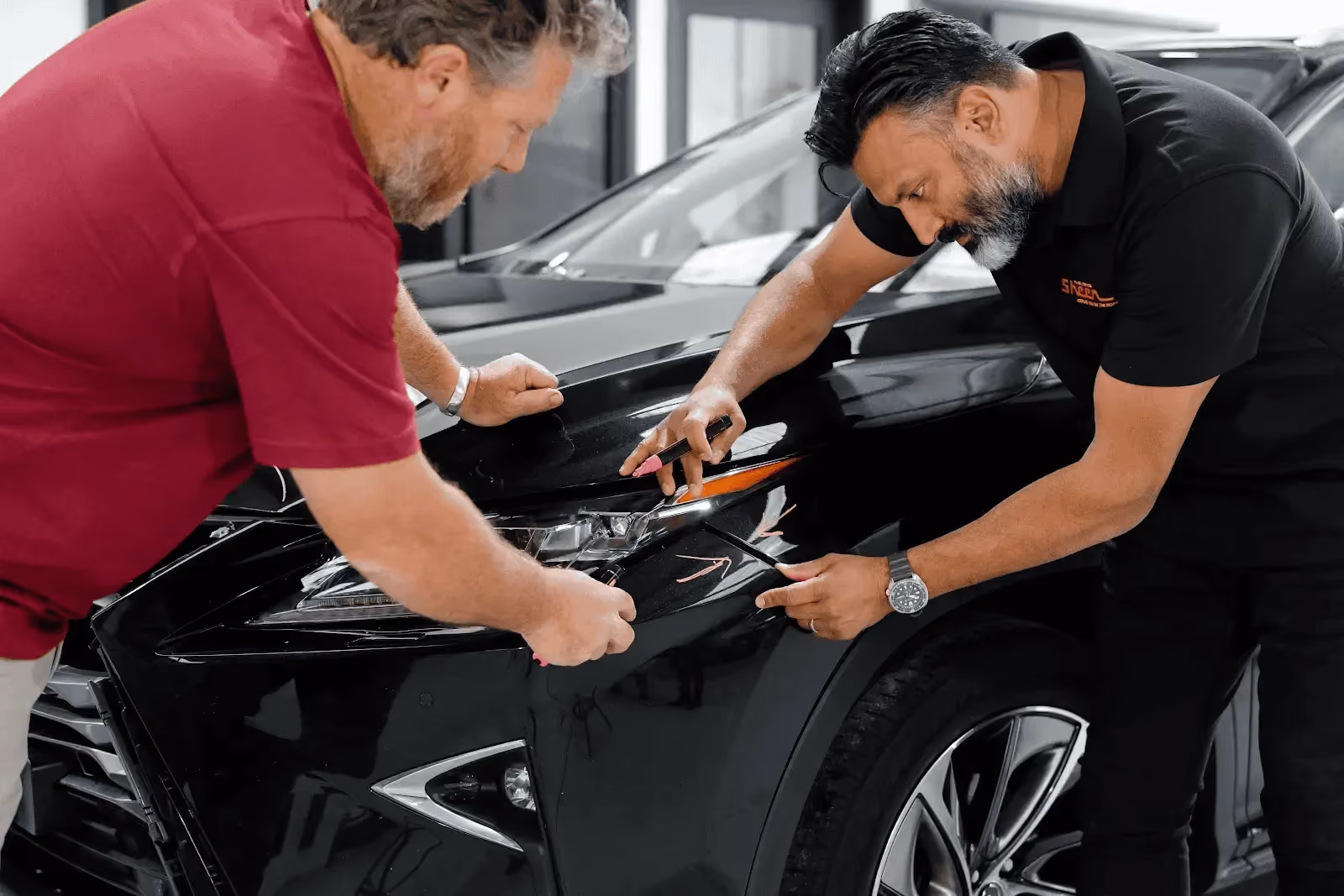 Sheen repair specialist assessing vehicle damage before insurance repairs.