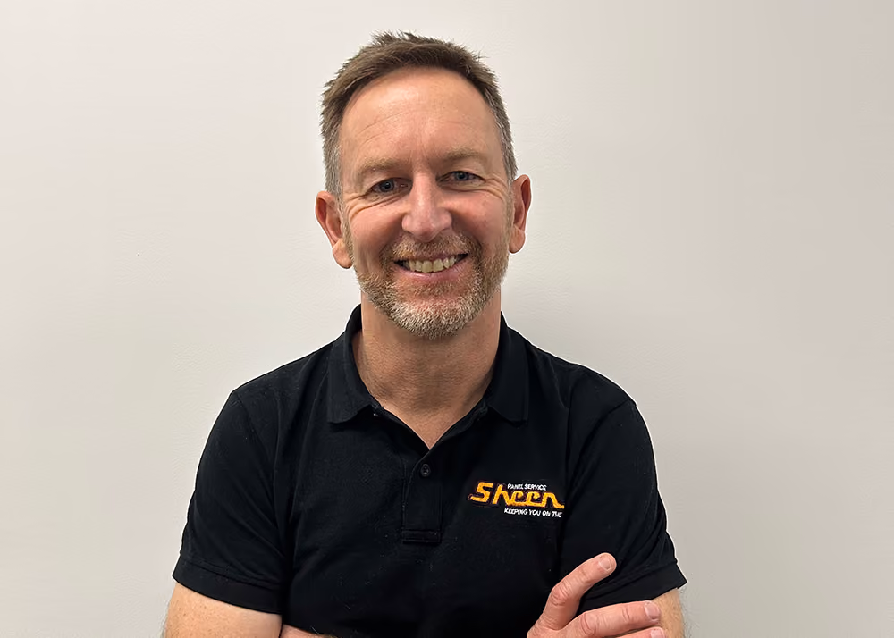 Portrait of Jason Trewin smiling with his arms crossed.