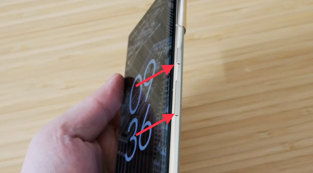 A close up of an android phone with arrows pointing at the power and low volume button indicating how to take a screenshot