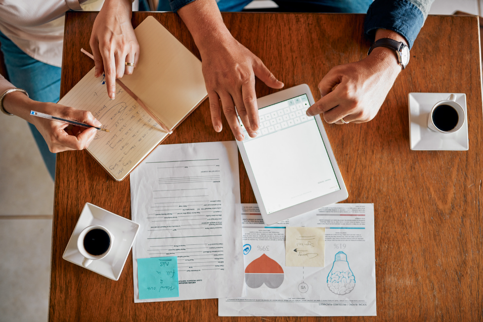 Two people discussing ideas on a desk using different materials