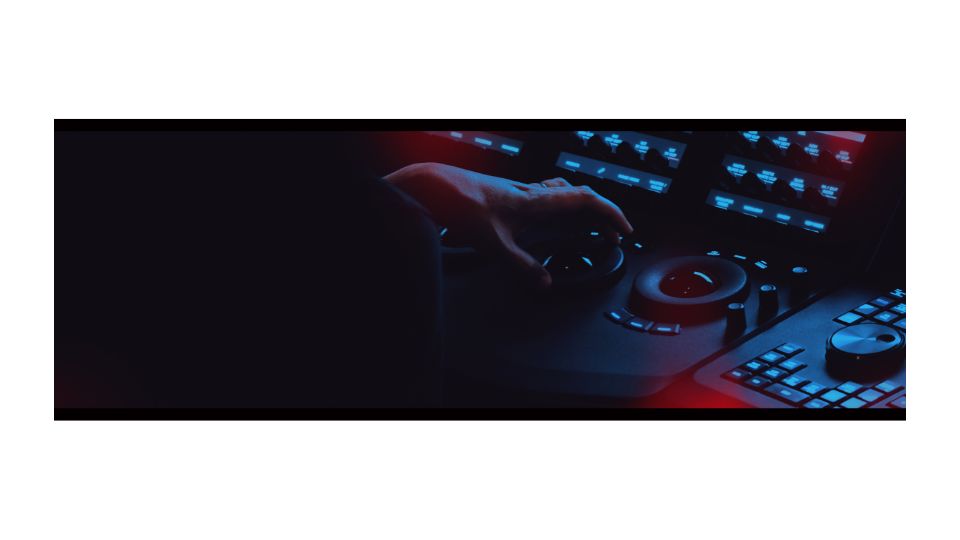 A person's hand turning a dial on a production desk.