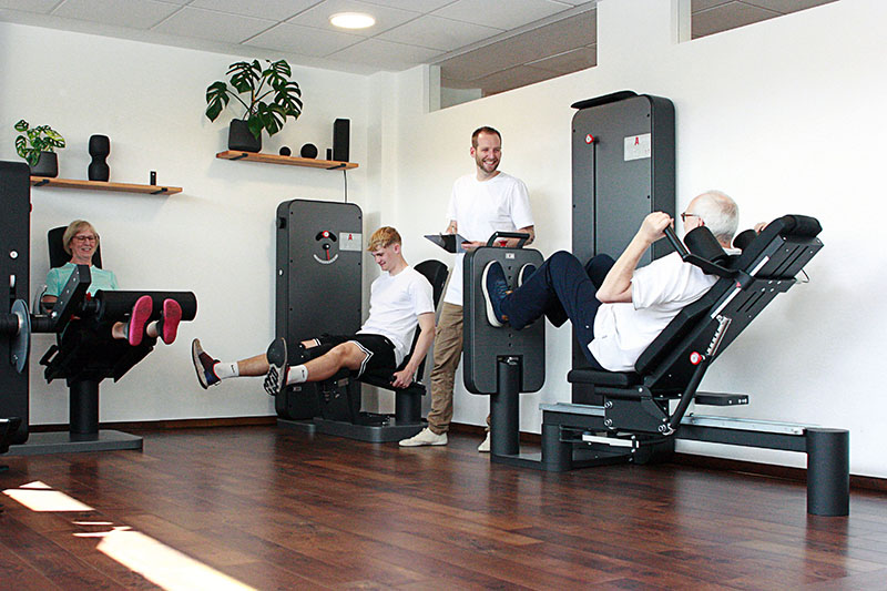 Physiotherapeut beim Training mit Patienten im Fitnessstudio