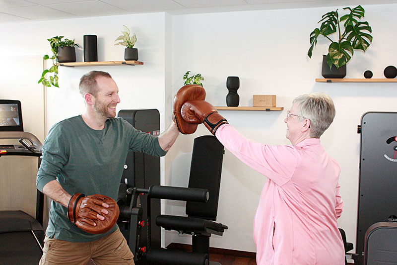 Physiotherapeut übt Boxen mit Patientin