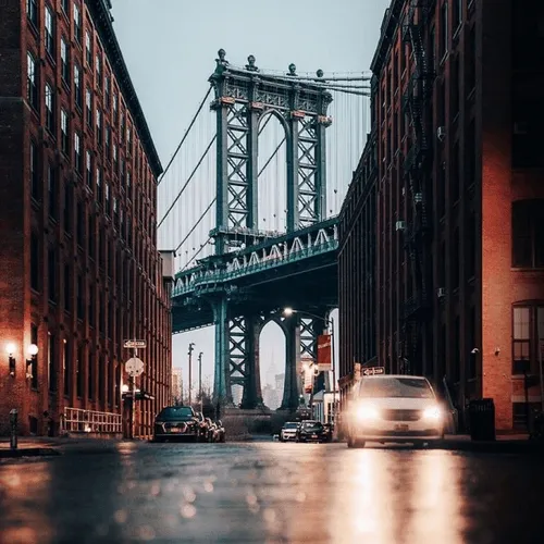 Towers of a suspension bridge as seen from street level a few blocks from the river.