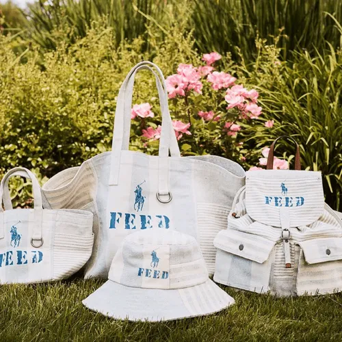 Several white bags with the Feed logo in a garden.