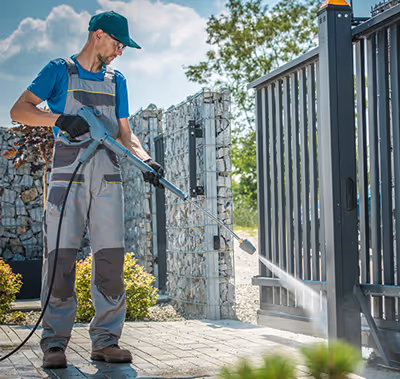 Technician pressure washing a common area.