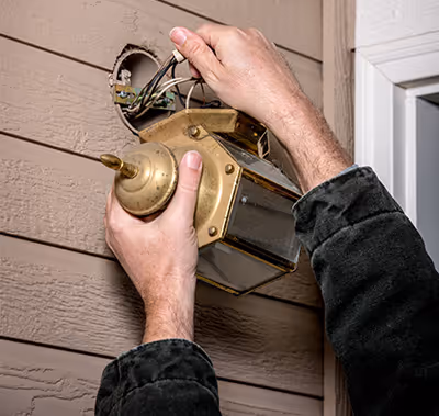 Technician replacing a light fixture.