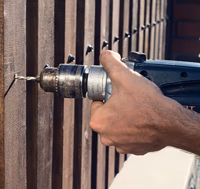 Technician making repairs to a fence.
