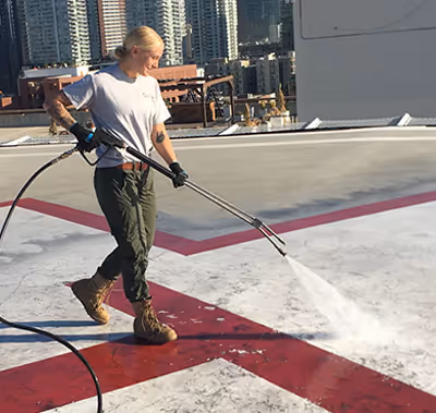 Technician pressure washing production area.
