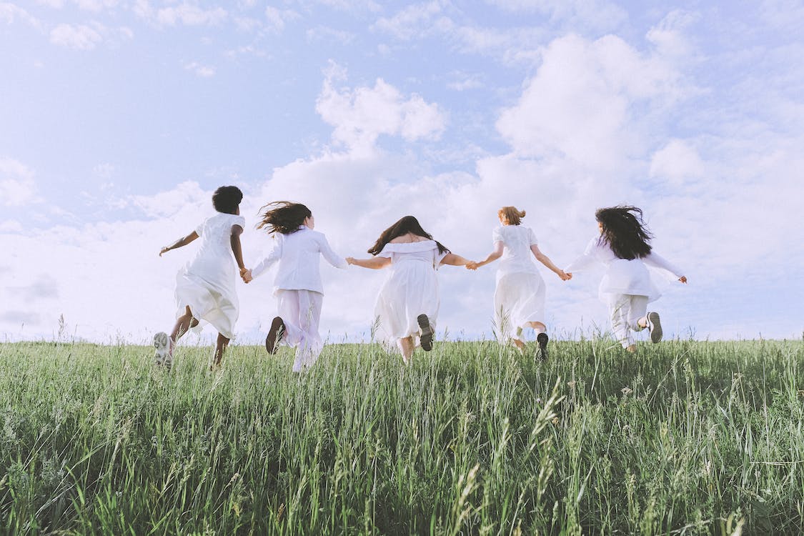 Free Group Of Women Running on Green Grass Field Stock Photo