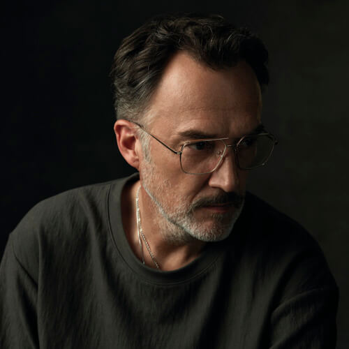 Mann mit langen Haaren und Götti Brille