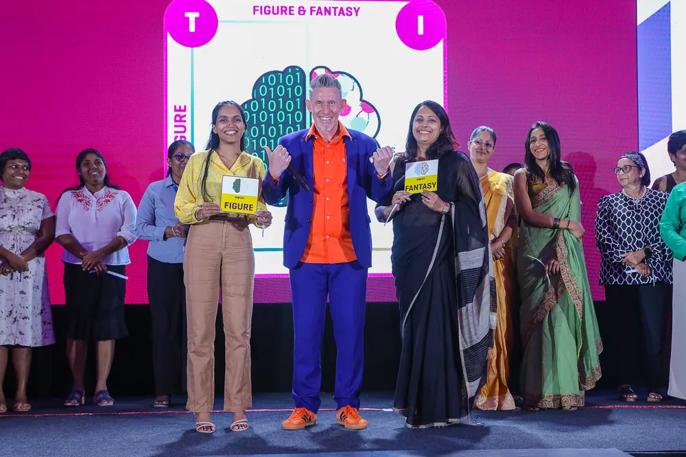 Facilitator on stage with participants holding TIPS cards at a leadership forum in Sri Lanka