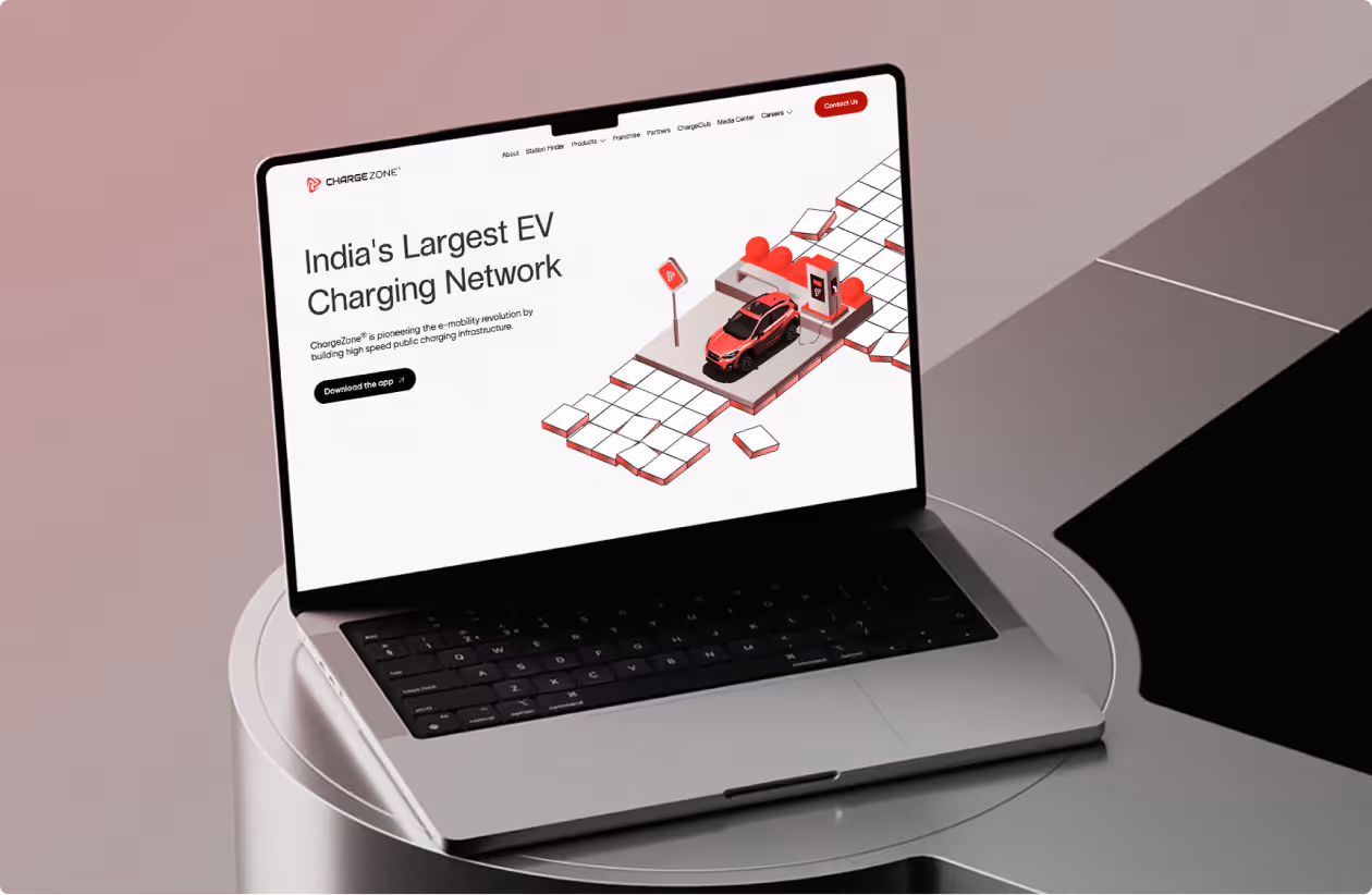 Laptop screen showing ChargeZone website promoting India's largest EV charging network with a red car at a charging station graphic.
