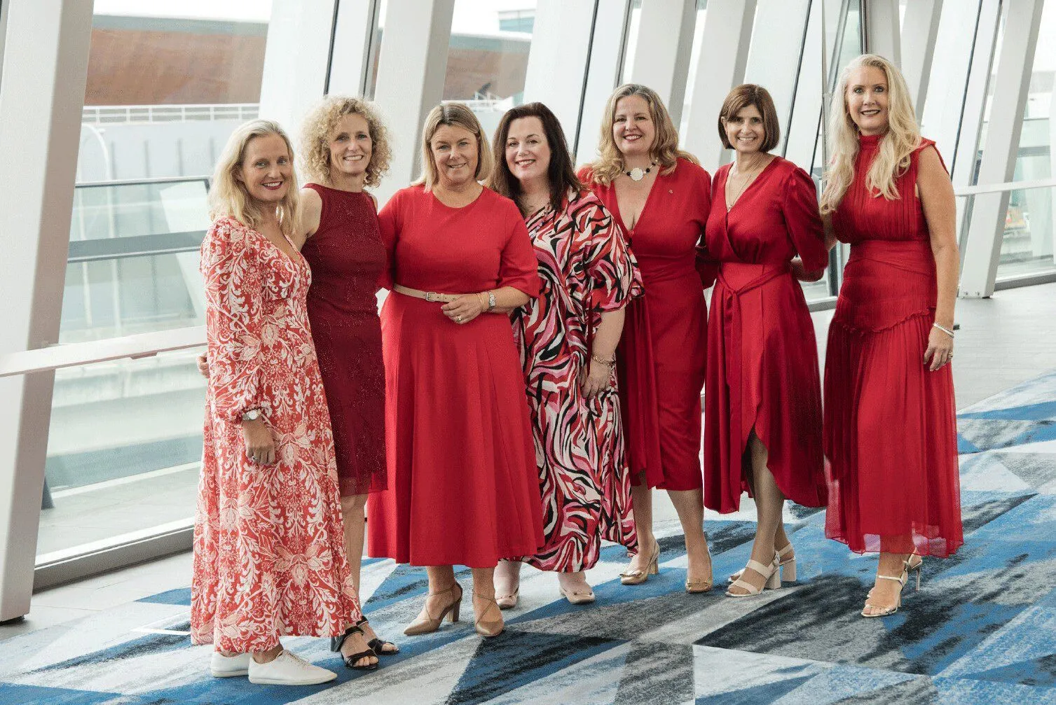 Gidget's founders pose for a photo, all in red.