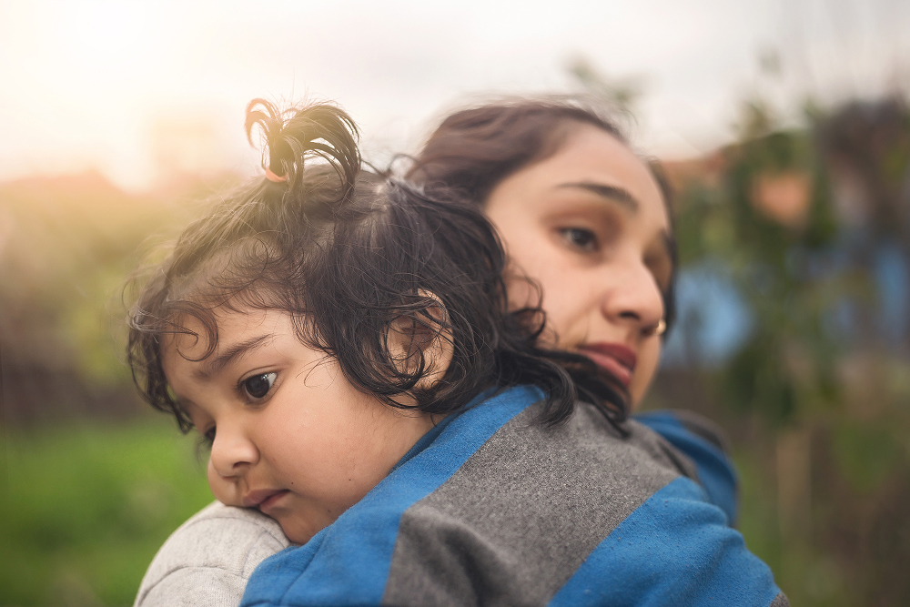 Indian mother lovingly holds her baby in her arms, showcasing a tender moment between them.