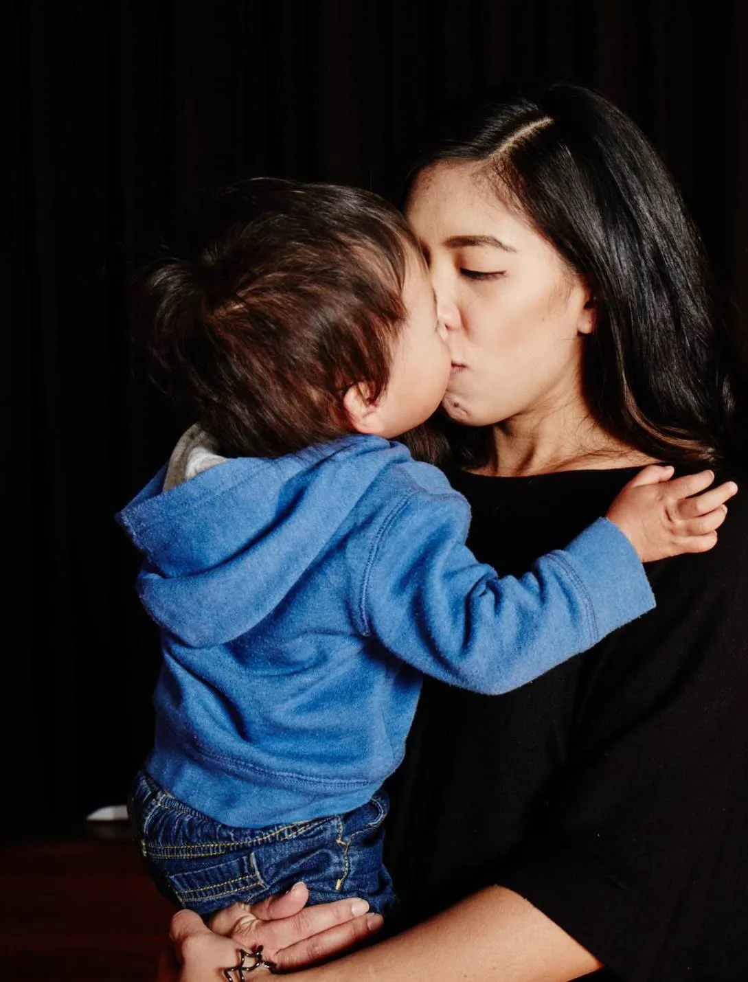 Joy kisses her toddler son tenderly.