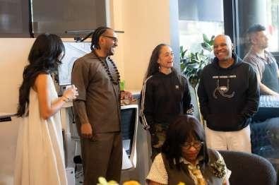 Five people posing together and smiling at the open house