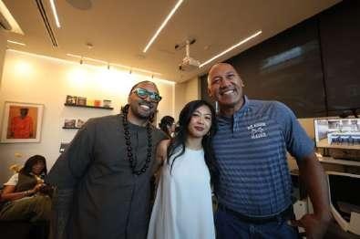 Three people posing together, smiling at the camera during the event