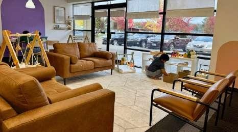 Leather armchairs and a couch in a lounge area at Laro Tayo, with a play structure visible in the background