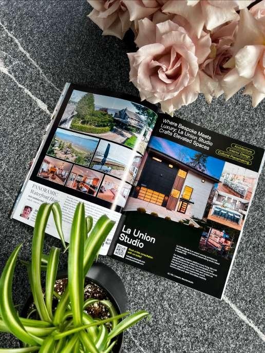 Open magazine spread featuring La Union Studio's work in HAVEN Lifestyle Magazine, resting on a concrete surface next to pink roses and a potted plant