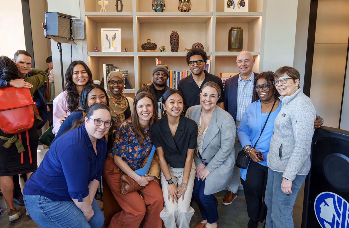 Large group of about thirteen people posing together indoors for La Union Studio's grand opening event, including Seattle city officials