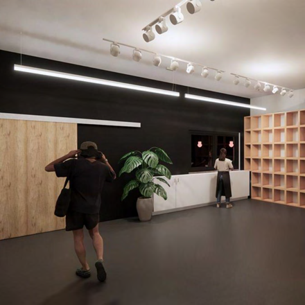 Architectural rendering of a modern interior reception area with track lighting, wood paneling, and a person taking a photo